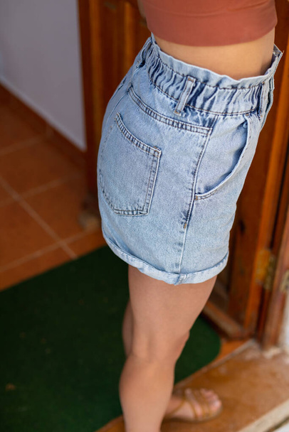 Slim girl in denim shorts, high waisted blue shorts close-up - Photo, Image