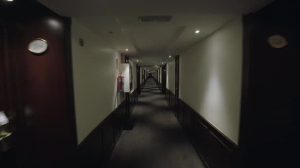 La steadicam filmò una passeggiata lungo il lungo corridoio dell'hotel. Carta da parati grigio e grandi porte di legno marrone - Filmati, video