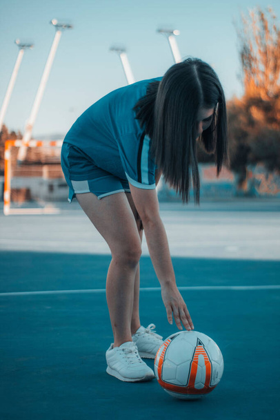A beautiful female playing football on the football pitch - 写真・画像