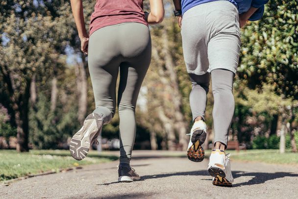 Achteraanzicht van twee runner legs in park - Foto, afbeelding