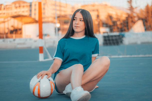 A beautiful female football player posing on the football pitch - Фото, зображення