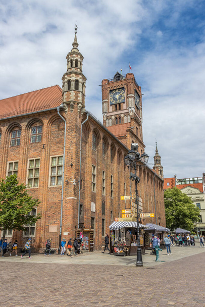 A vertical shot of an outdoor cafe in front of the beautiful traditional buildings of Torun, Poland - Fotoğraf, Görsel