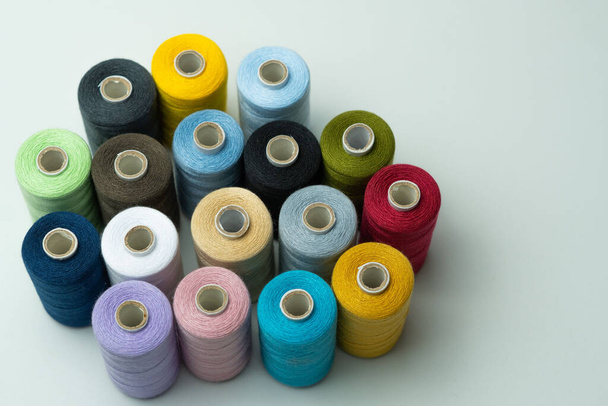 spools of colored sewing thread on white background with copy space - Photo, image
