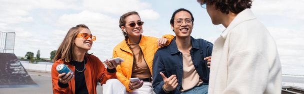 feliz asiático homem mostrando polegar para cima enquanto passar tempo com jovens amigos ao ar livre, banner - Foto, Imagem
