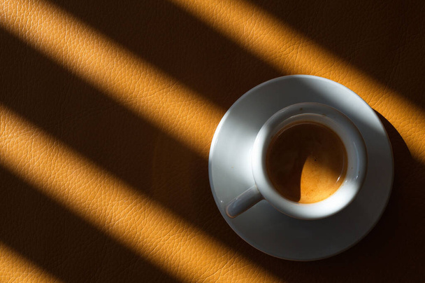 A top view of a cup of espresso on a cream leather surface - Fotoğraf, Görsel