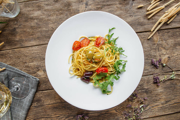 Porción de pasta italiana de espagueti con aceitunas y hierbas - Foto, Imagen