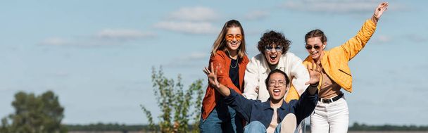 excited asian man screaming while having fun with friends outdoors, banner - Fotografie, Obrázek