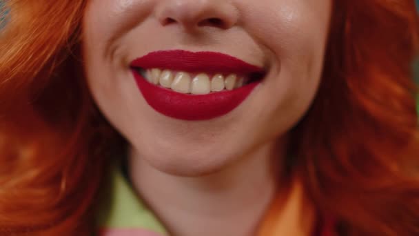 Genç mutlu kızıl saçlı kadının portresi gülümseyen ağız, mükemmel beyaz, sağlıklı dişleri olan sevimli kızıl kız. Kırmızı ruj. Dişi cilt modeli kameraya geniş açıyla gülümser. - Video, Çekim