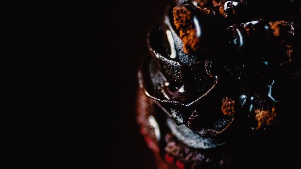 Eine Nahaufnahme eines Schokoladenkuchens isoliert auf schwarzem Hintergrund - Foto, Bild