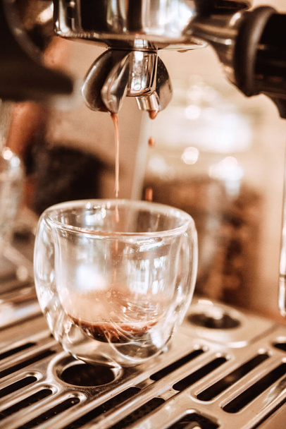 A vertical closeup of a barista making a fresh coffee - Photo, Image