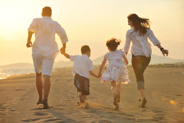 heureux jeune famille amusez-vous sur la plage au coucher du soleil - Photo, image