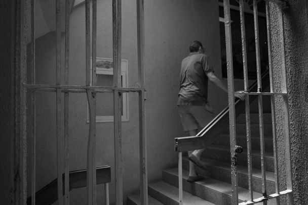 A greyscale shot of a man on the stairs - Φωτογραφία, εικόνα