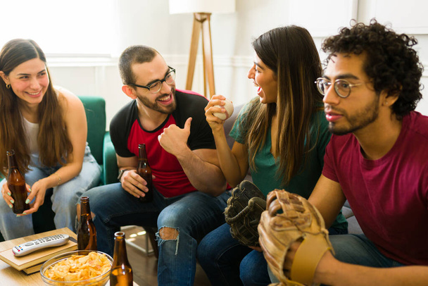Пара друзів дивиться бейсбольну гру на телевізорі, насолоджуючись пивом і закусками
 - Фото, зображення