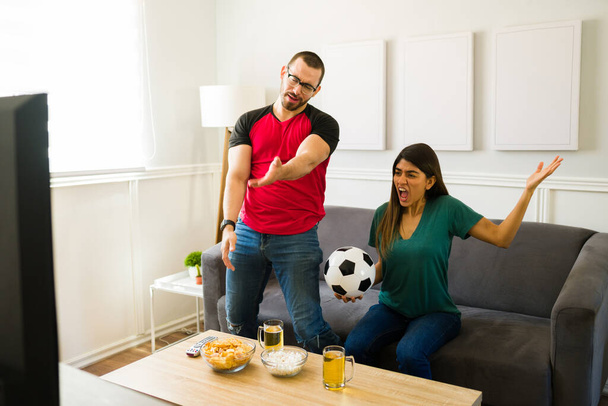 Απογοητευμένο ζευγάρι αισθάνεται αναστατωμένος και θυμωμένος για την εθνική ομάδα ποδοσφαίρου χάνει το παιχνίδι στην τηλεόραση - Φωτογραφία, εικόνα