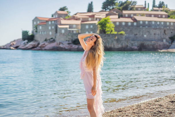 Woman tourist on background of beautiful view of the island of St. Stephen, Sveti Stefan on the Budva Riviera, Budva, Montenegro. Travel to Montenegro concept. - Foto, Bild