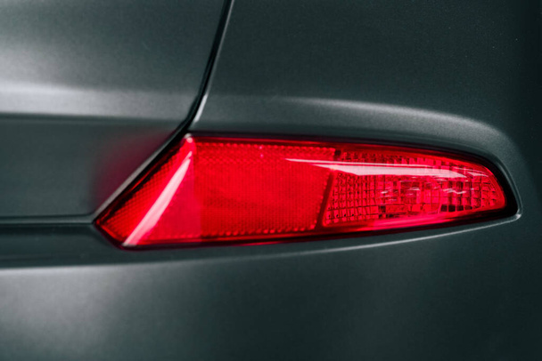 A closeup shot of the red rear light of a grey car - Foto, Imagen