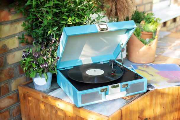 Vinyl blue record player at home. Modern phonograph record concept in trendy colors. Stylish Record player with vinyl disc on table in room. Interior of room with record player - Foto, imagen