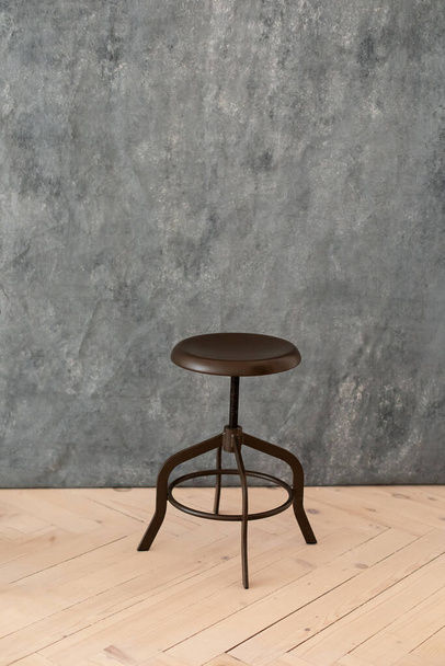 chaises métalliques minimalistes noires sur fond gris. Concept intérieur moderne et mobilier design dans la chambre. Tabouret haut en style loft. Chaise de bar rétro. Chaise métal bois vintage. Grande table debout - Photo, image
