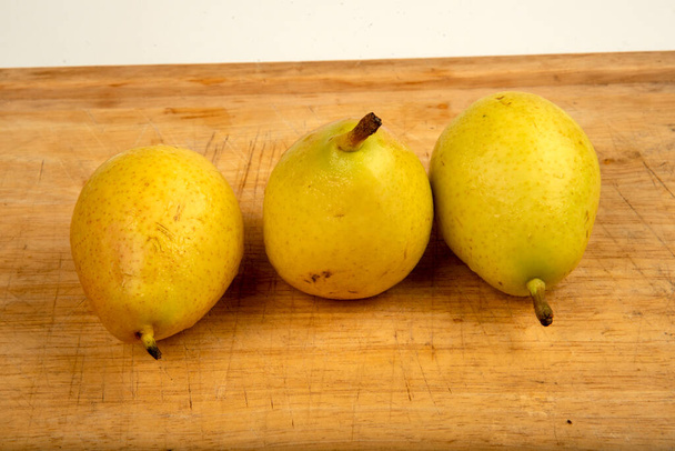 Спелые жёлтые груши на деревянной доске, сезонные фрукты - Фото, изображение