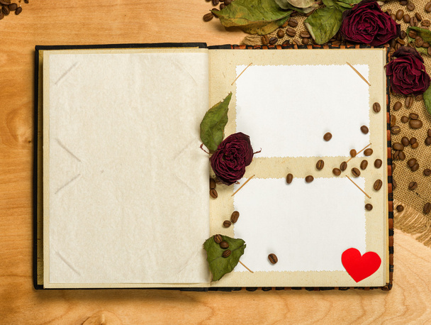 photo album and dry red roses on coffee seeds - Photo, Image