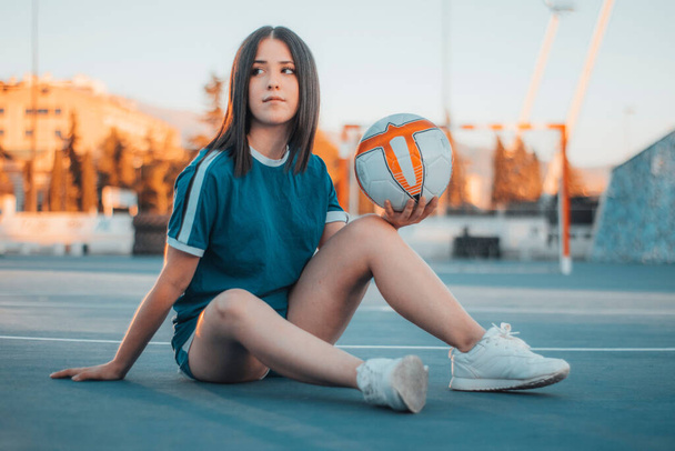 A beautiful female football player posing on the football pitch - Foto, imagen