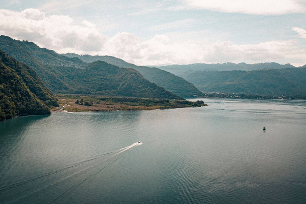 An aerial shot of the Lake Atitlan in the background of mountains on a cloudy day. - Foto, Imagem