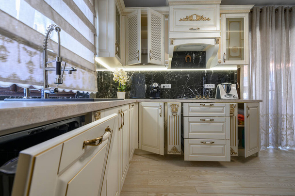 Blanco rico clásico acogedor cocina y comedor en el interior de la casa de la ciudad, algunos cajones están abiertos - Foto, Imagen