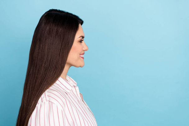 Profile side view portrait of attractive well-groomed cheerful long-haired girl copy space ad isolated over blue pastel color background. - Φωτογραφία, εικόνα