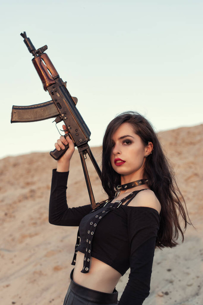 Girl with a gun in her hands - Foto, afbeelding
