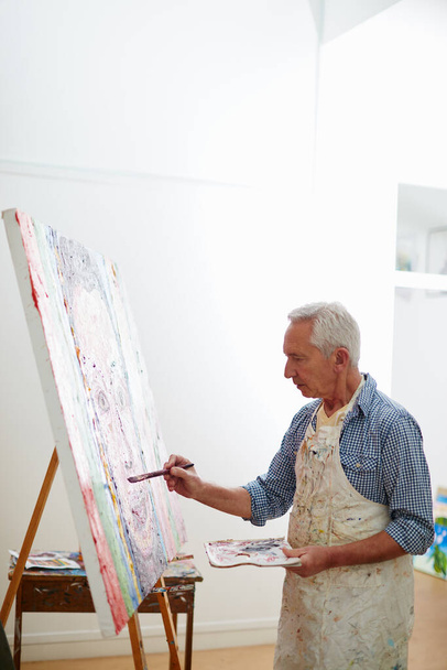 Shot of a senior man working on a painting at home. - Foto, Imagen