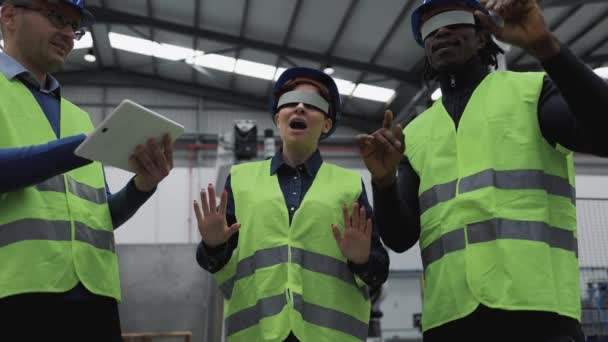 Team of engineers having simulation experience with futuristic virtual reality glasses inside robotic factory - Tech industry and metaverse concept  - Felvétel, videó