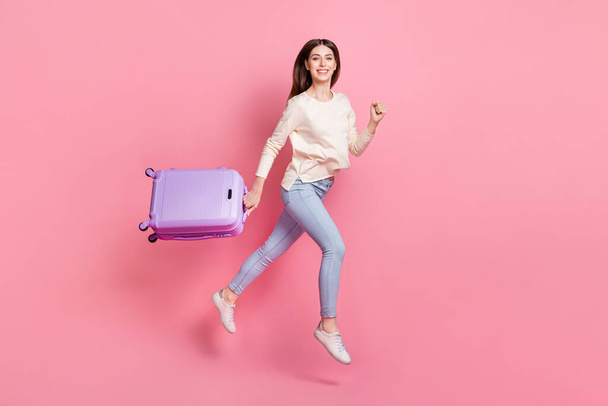 Full length body size view of attractive cheerful skinny girl holding bag jumping going isolated over pink pastel color background. - Foto, Bild
