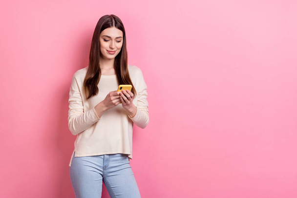 Portrait of attractive cheery focused brown-haired girl using device app copy space isolated over pink pastel color background. - Foto, Imagen