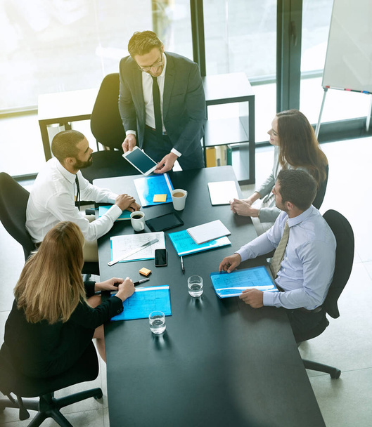Aufnahme eines Teams von Führungskräften bei einer formellen Besprechung in einem Vorstandssaal. - Foto, Bild
