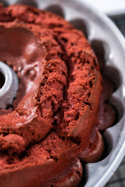 Cooling freshly baked red velvet bundt cake on a kitchen drying rack. - Foto, afbeelding