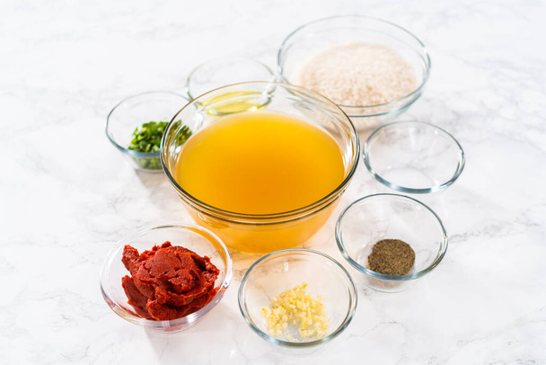 Measured ingredients in glass mixing bowls to prepare Mexican rice. - Foto, Imagem