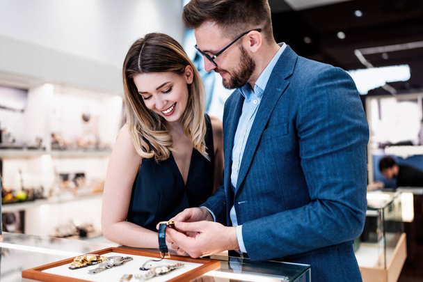 Beautiful couple enjoying in shopping at modern jewelry store. Men fashion and elegance  concept. - 写真・画像