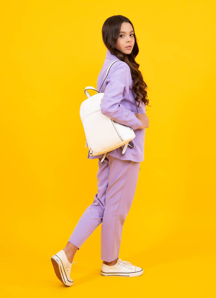 Back to school. Teenager schoolgirl in school uniform with backpack. School children on isolated studio background - Foto, afbeelding