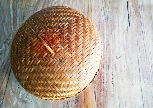 Tampa de placa de material de bambu, com pinças de metal, colocada sobre fundo de madeira marrom - Foto, Imagem