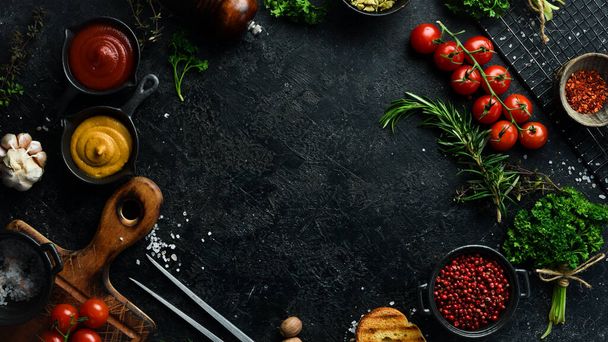 Black stone cooking background. Spices and vegetables. Top view. Free space for your text. - Foto, Bild