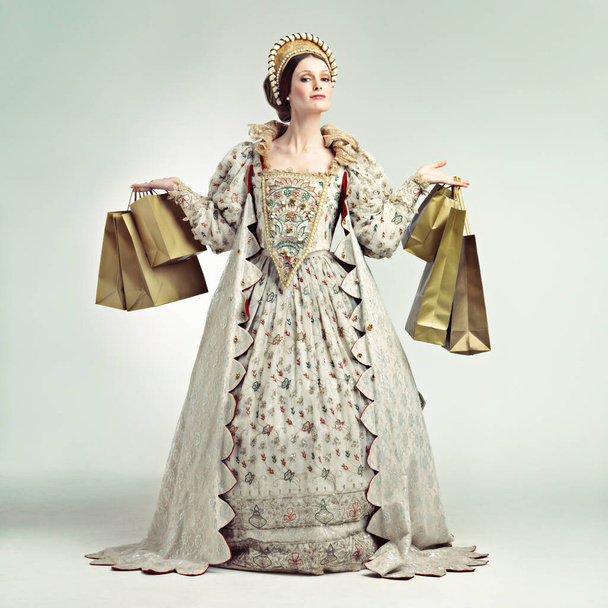 A gorgeous Victorian queen holding parcels. - 写真・画像