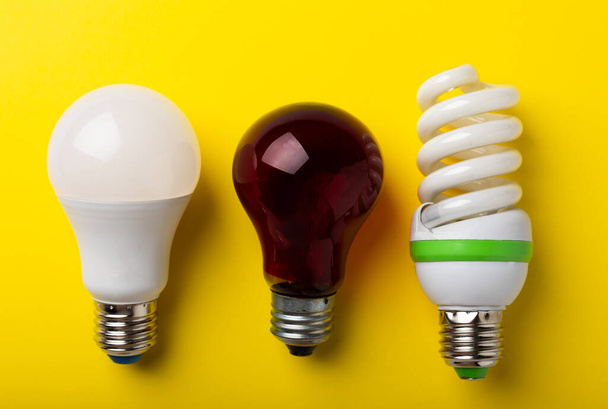 Villanykörték. az energiahatékonyság fogalma. LED lámpa vs izzó lámpa. Összetétel sárga alapon. Gazdaságos és környezetbarát villanykörte-koncepció alkalmazása. - Fotó, kép