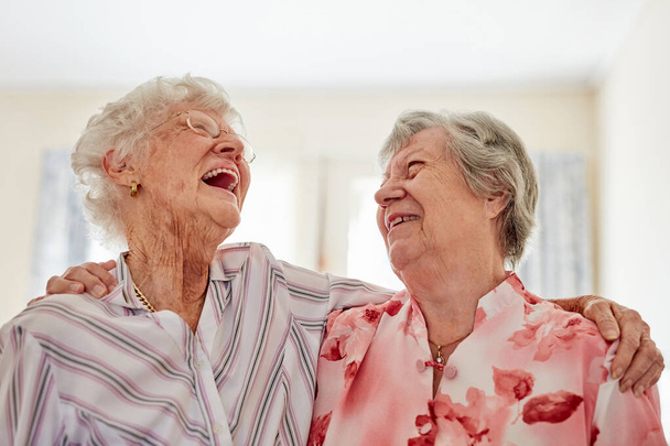 Aufnahme zweier glücklicher älterer Frauen, die sich zu Hause umarmen. - Foto, Bild