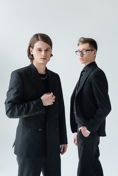 Young gay couple in formal wear looking at camera isolated on grey  - Foto, immagini