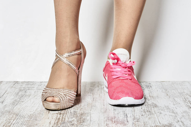 Δύο διαφορετικοί τύποι παπουτσιών στα πόδια των γυναικών. - Φωτογραφία, εικόνα