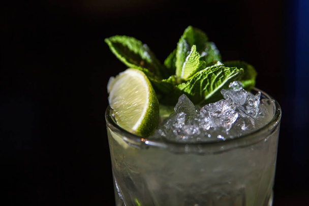 Mojito, cocktail close-up on a black background. Lime slice, mint and ice. High quality photo - Zdjęcie, obraz