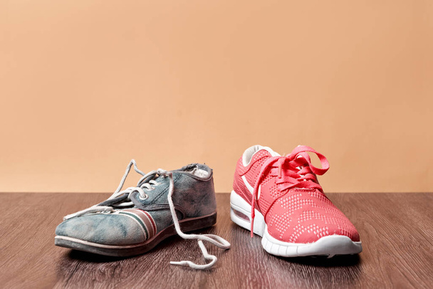 Concept of rich and poor in a , old asneakers and new sneakers - Fotoğraf, Görsel