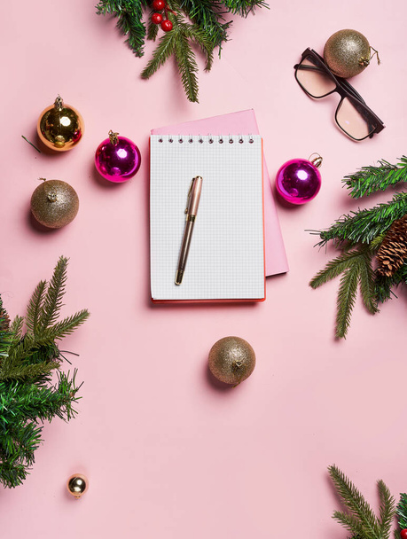 Vánoční pozadí s prázdným notebook obklopen vánoční dekorace. Dopis Santa nebo vánoční nákupní seznam na růžové backgraund - Fotografie, Obrázek