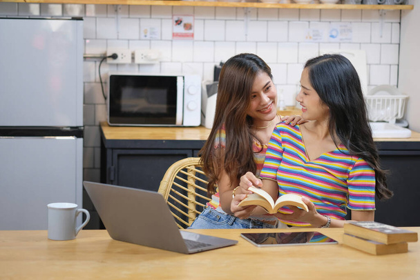 lgbtq lgbt concetto di omosessualità Due belle donne esprimono felicemente il loro amore per l'altro giocando computer portatili nelle loro case confortevoli. - Foto, immagini