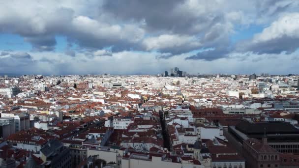 Madridból, Spanyolországból. Felhők vitorláznak a lakónegyedek felett. Fehér homlokzatú házak napfényes barna háztetői a sűrűn beépített kerületben - Felvétel, videó